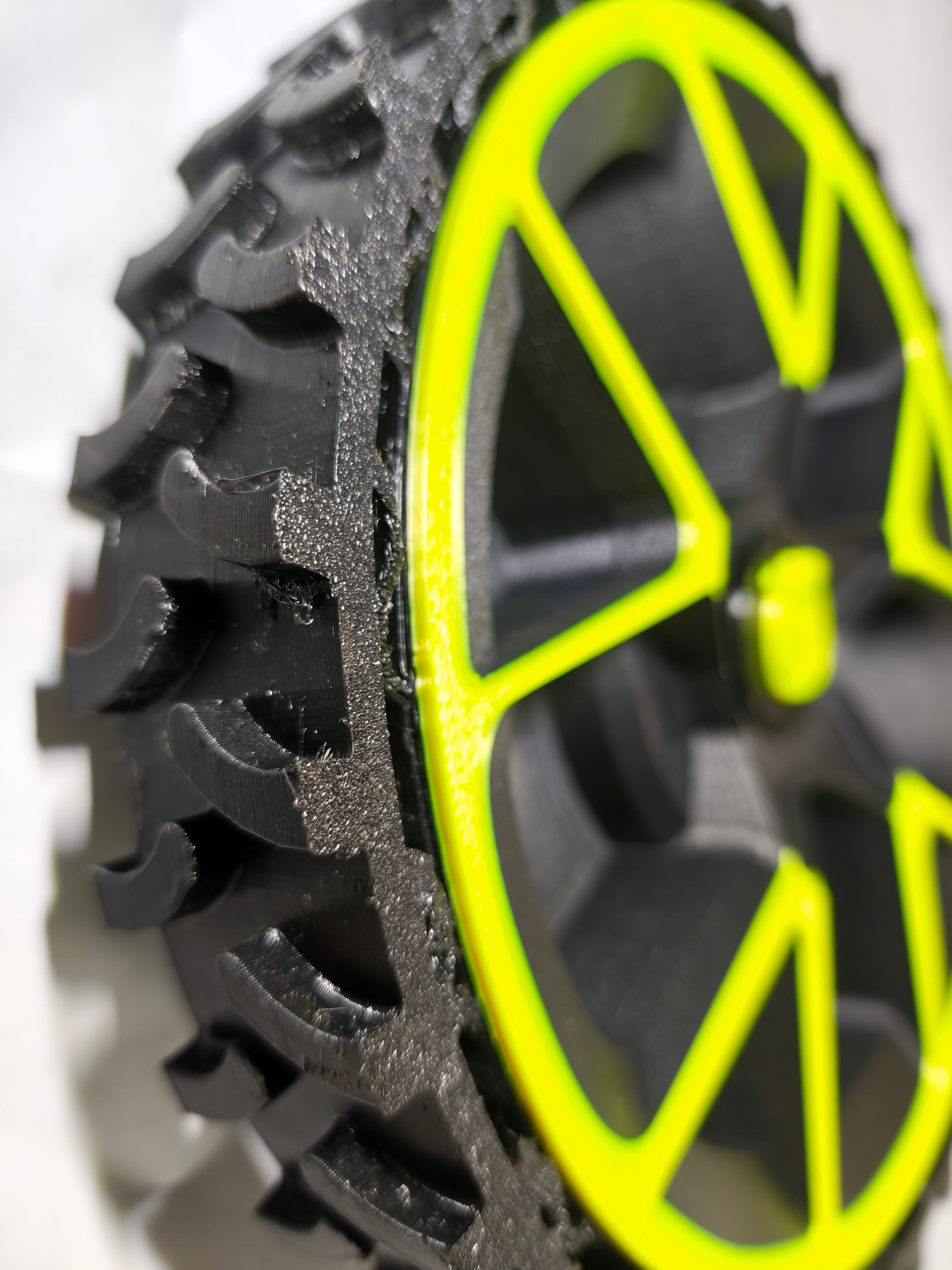 Close-up of a tire with a yellow rim on a white background